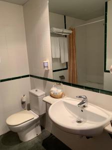 biała łazienka z toaletą i umywalką w obiekcie Hotel Área de Calahorra w mieście Calahorra +19 zdjęć