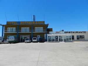 Hotel Área de Calahorra في كالاهورا: مبنى كبير به سيارات تقف في موقف للسيارات