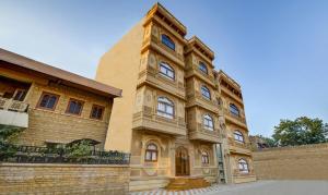 Hotel Chandrangan Excellency,Jaisalmer في جيلسامر: مبنى بجانبه برج ساعه