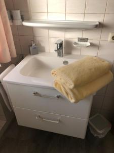 a bathroom with a sink with a towel on it at Gästehaus Aurikel 16 in Fischen