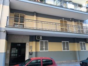 un coche rojo estacionado frente a un edificio en B&b Il Bacio, en Modugno