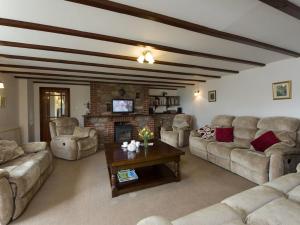 ein großes Wohnzimmer mit Sofas und einem Kamin in der Unterkunft Valley House in Tiverton