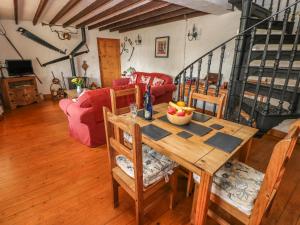 a dining room with a table with a bowl of fruit on it at Primose Cottage in Milford Haven