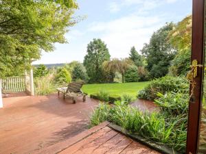 a bench sitting on a patio with a garden at Frog Meadow Barn in Biddulph