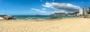 a sandy beach with a view of the ocean at Hotel Porto Calpe in Calpe