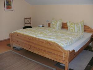 Cette chambre comprend un grand lit en bois. dans l'établissement Ferienwohnung Klaus, à Oy-Mittelberg