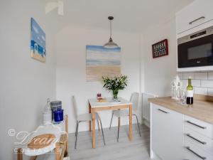 a kitchen with a table and chairs in a kitchen at Sea Drift in Weymouth
