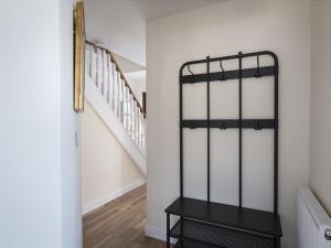 a hallway with a black shelf next to a staircase at 4 Armada House in Hope Cove