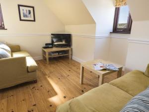 a living room with a couch and a table at 4 Armada House in Hope Cove
