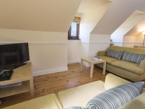 a living room with a couch and a tv at 4 Armada House in Hope Cove