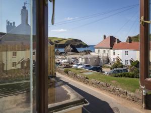 a view from a window of a street and houses at 4 Armada House in Hope Cove