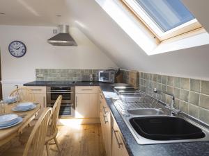 a kitchen with a sink and a table with chairs at 4 Armada House in Hope Cove