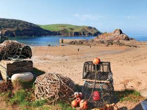 a beach with nets and fruit on the sand at 4 Armada House in Hope Cove