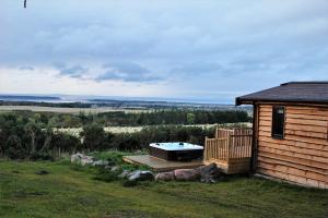 a house with a hot tub on the side of it at Burgie Woodland Lodges in Forres