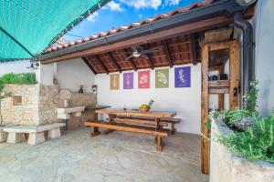 an outdoor patio with a wooden table and benches at Holiday home Škrika in Škrip