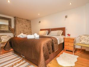 a bedroom with a large bed and a stone wall at The Old Barn in Penzance