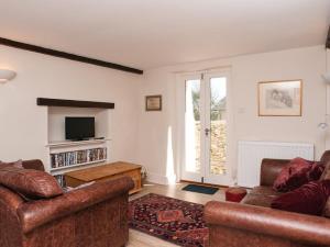 a living room with two couches and a television at Hazel Cottage in Malborough