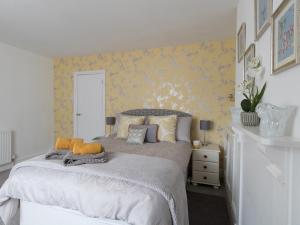 a bedroom with a large bed with yellow wallpaper at Sunny Days in Weymouth