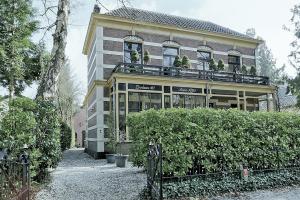 a building with a balcony on top of it at In het koetshuis in Apeldoorn