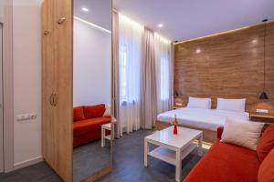 a hotel room with a bed and a red couch at 5 STAR APART HOTEL in Tbilisi City
