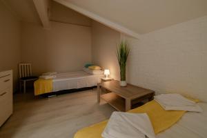 a small room with a bed and a table at GUZ Apartamenty in Giżycko