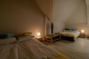 ギジツコにあるGUZ Apartamentyのベッド2台とランプ2つが備わる部屋