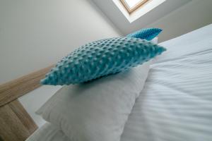 a bed with a blue and white blanket on top of it at GUZ Apartamenty in Giżycko
