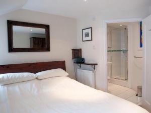 a bedroom with a white bed and a mirror at Aeolus House in Dartmouth