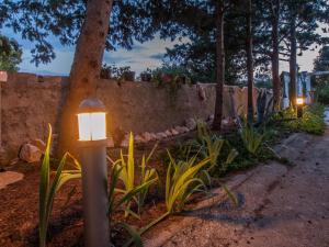 ein Straßenlicht in einem Garten neben einer Mauer in der Unterkunft Silba Otium in Silba