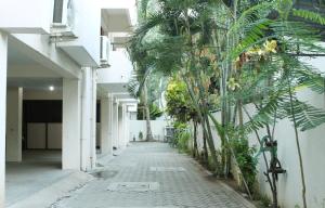 a corridor of a building with a bunch of palm trees at Phoenix Serviced Apartment - 14th Main Road, Anna Nagar in Chennai