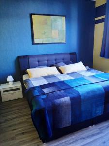 1 dormitorio azul con 1 cama con pared azul en Ferienwohnung alte Stepperei, en Schwarzenberg