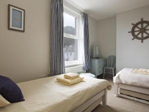 ein Schlafzimmer mit einem Bett und einem Fenster in der Unterkunft Crab Cottage in Salcombe