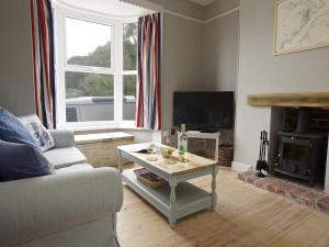 ein Wohnzimmer mit Sofa und Tisch in der Unterkunft Crab Cottage in Salcombe