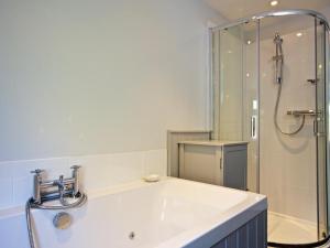 ein Badezimmer mit einem weißen Waschbecken und einer Dusche in der Unterkunft Crab Cottage in Salcombe + 17 Fotos