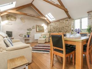 a kitchen and living room with a table and chairs at Barneys Barn in Penzance