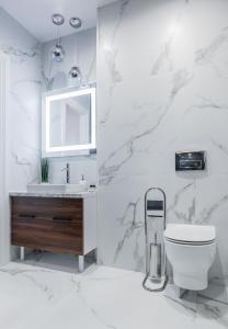 a white bathroom with a toilet and a sink at Amsterdam Lviv Apartments in Lviv +76 photos