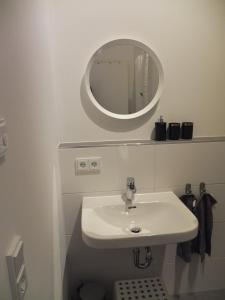 uma casa de banho branca com um lavatório e um espelho em Ferienwohnung Sauer em Blaichach