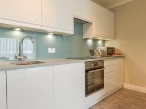 a kitchen with white cabinets and a sink at 3 Tarifa in Bigbury on Sea