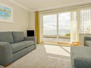 uma sala de estar com um sofá e uma grande janela em 3 Tarifa em Bigbury on Sea