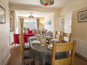 een eetkamer met een tafel en stoelen en een woonkamer bij Camar in Salcombe