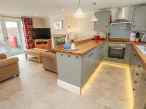 a kitchen with white cabinets and a counter top at Pottery Cottage in Kilgetty +22 photos