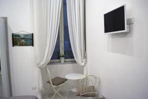 Cette chambre dispose d'une fenêtre avec une table et une chaise. dans l'établissement Le Stanze di Dolly, à Naples