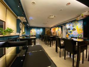 un comedor con mesas y sillas en un restaurante en JS Hotel-Gallery Hotel, en Zhongli