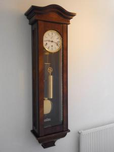 een grootvaders klok hangend aan een muur bij The Old Clockmakers in Norwich