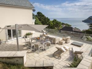 a patio with a table and chairs and an umbrella at The Sands in Salcombe