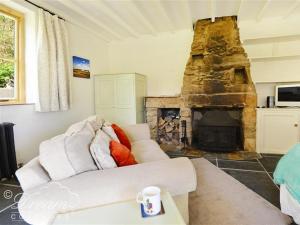 a living room with a couch and a fireplace at Valley View Farm Annexe in Uplyme
