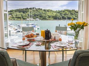 een tafel met een kom eten en uitzicht op een jachthaven bij 7 Dart Marina in Dartmouth