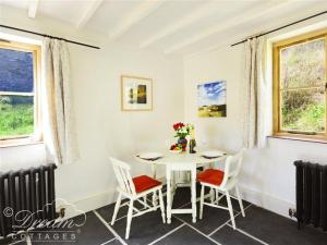 a dining room with a white table and chairs at Valley View Farm Annexe in Uplyme