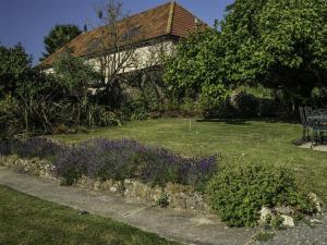 a garden with purple flowers in front of a house at Valley View Farm Annexe in Uplyme