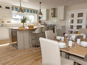 Una cocina con una mesa con sillas y una encimera. en Quayside, en Salcombe
